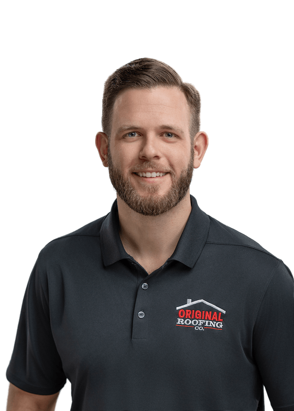 A man with a short beard and short hair is wearing a dark polo shirt with the logo "Original Roofing Co" on it, representing his roofing company. He is smiling and looking at the camera against a white background.